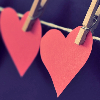 construction paper hearts held to a twine line with wooden paperclips