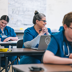 Medical students in the classroom studying with smiles on their faces