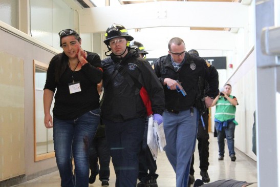 firefighter escorts injured woman out of building