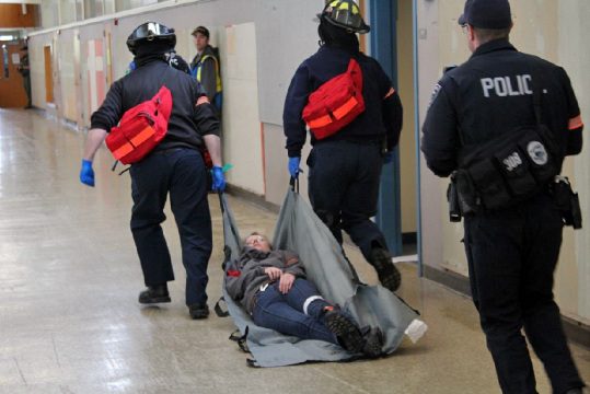 firefighters drag injured victim down hallway on a blanket
