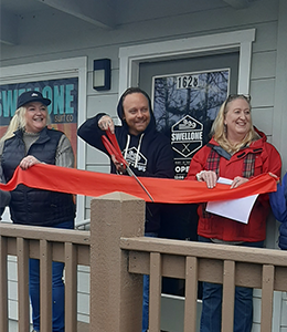 Michael Lick cutting the grand opening ribbon with members of the GH Chamber of Commerce