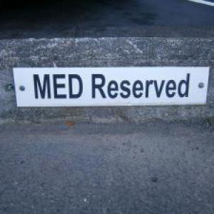 MED Reserved sign on parking lot curb