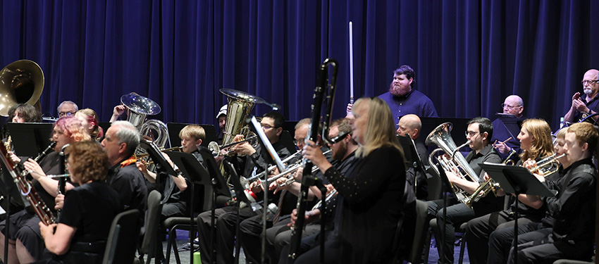 Members of the GH Concert Band playing instruments on stage