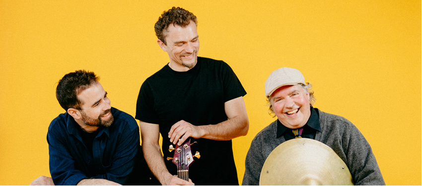 Three members of Duende Libre standing with their instruments