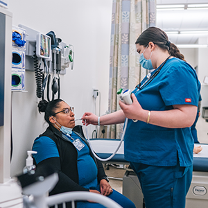 A medical assistant student taking a patient's temperature