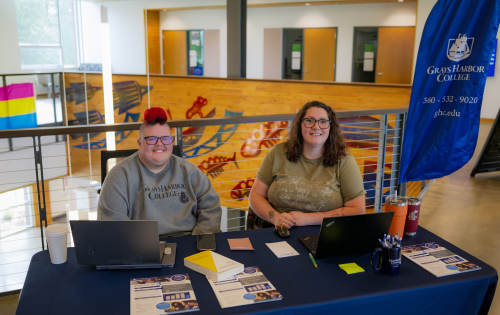 Advisors Jax and Hannah waiting to greet students at a registration event