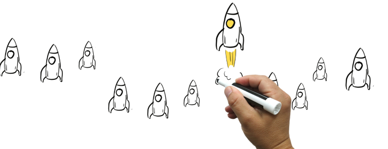 A hand drawing rocket ships on a whiteboard with red text that says, Apply Today!
