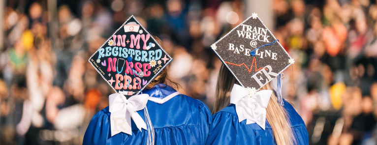 On a blue background are the words Nursing Applications are Open! Next to this is an image of two graduating nursing students and their decorated caps.