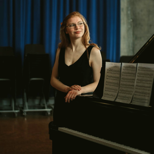 Sarah O'Hagan standing next to a piano