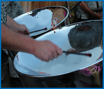 A close up of two steel drums being played.