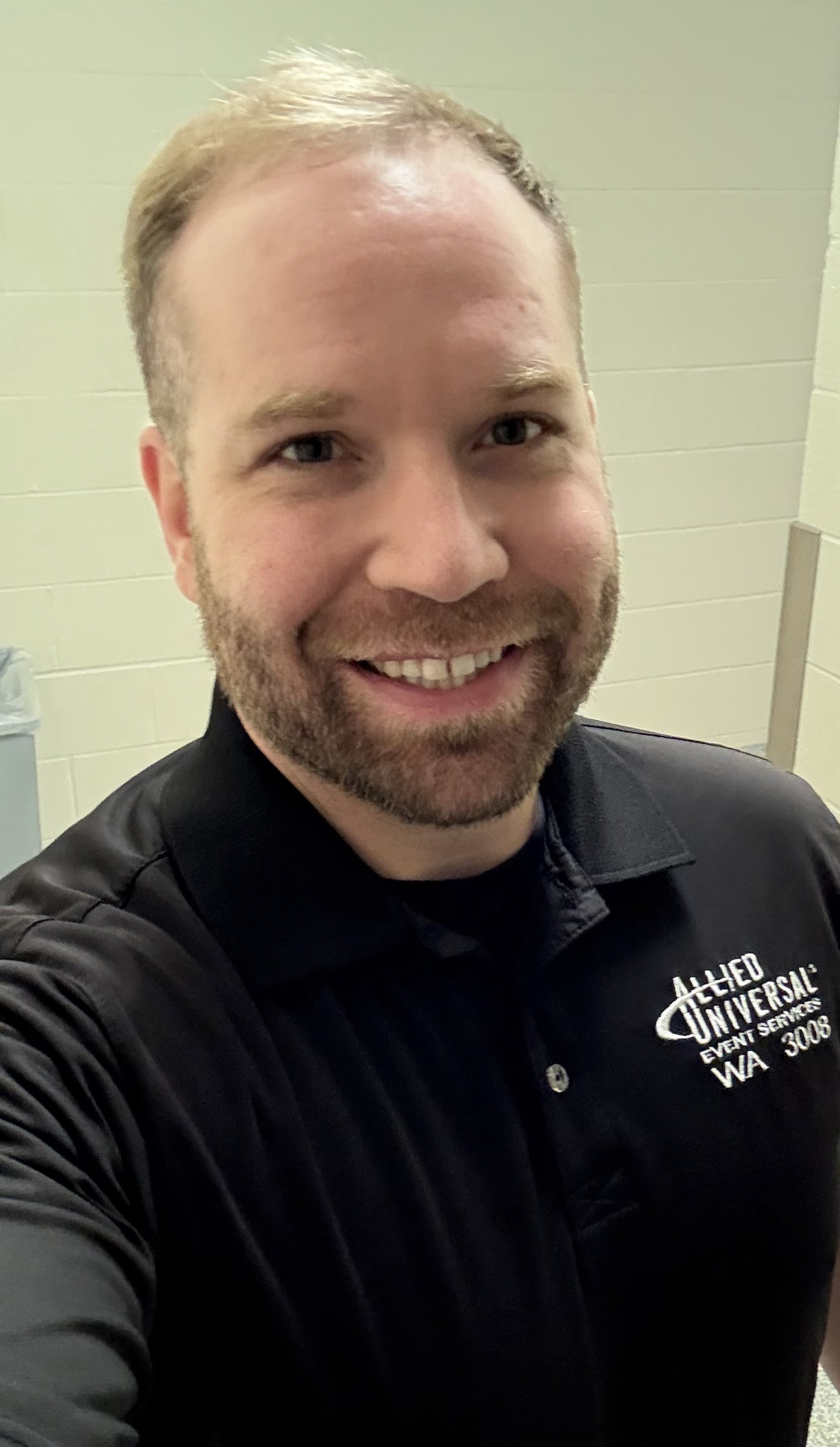 Austin smiles for the camera in a selfie, he is wearing an Allies Universal Event Services Polo.